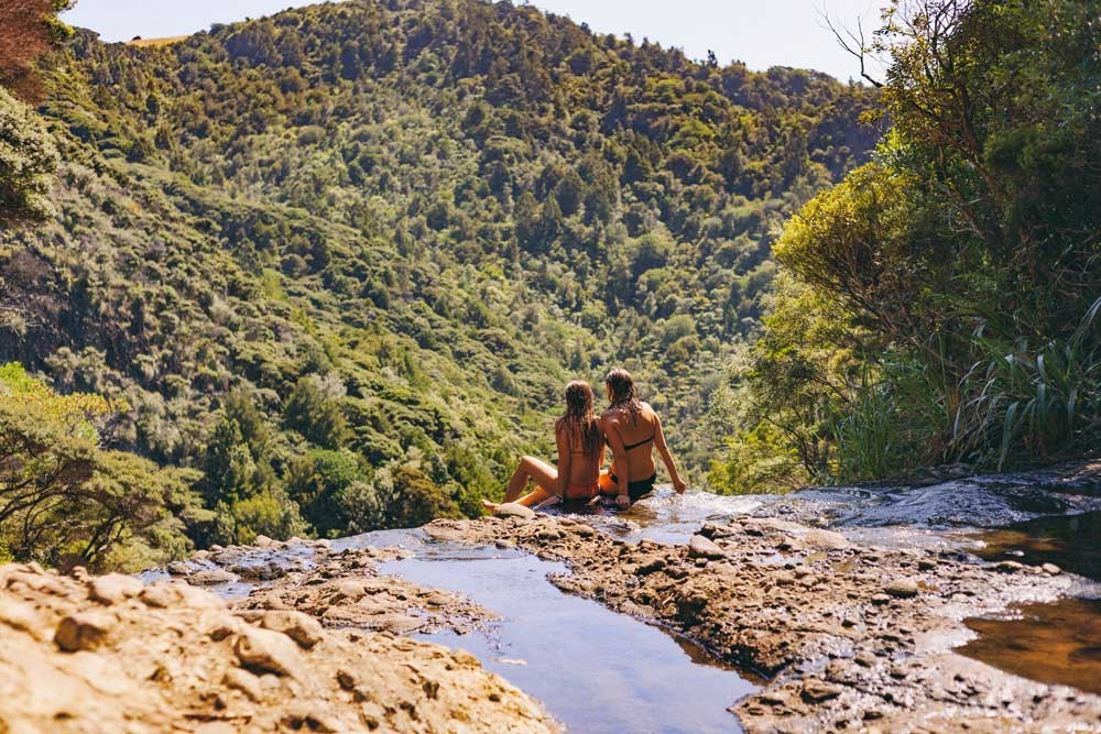 dos chicas de espaldas sentadas y delante la naturaleza